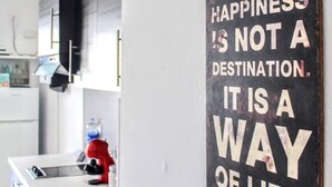 Una cocina con un letrero negro en la pared que dice "LA FELICIDAD NO ES UN DESTINO. ES UNA FORMA DE VIDA."