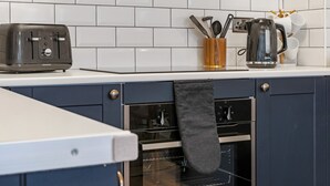 A kitchen with a toaster, a coffee maker, and a set of utensils in a holder. - Central 1BD Free Underground Parking (Cheltenham)