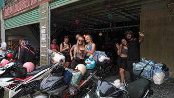 Un grupo de personas de pie frente a un edificio con un letrero que dice "MAX FUN HOMESTAY DU GIA".