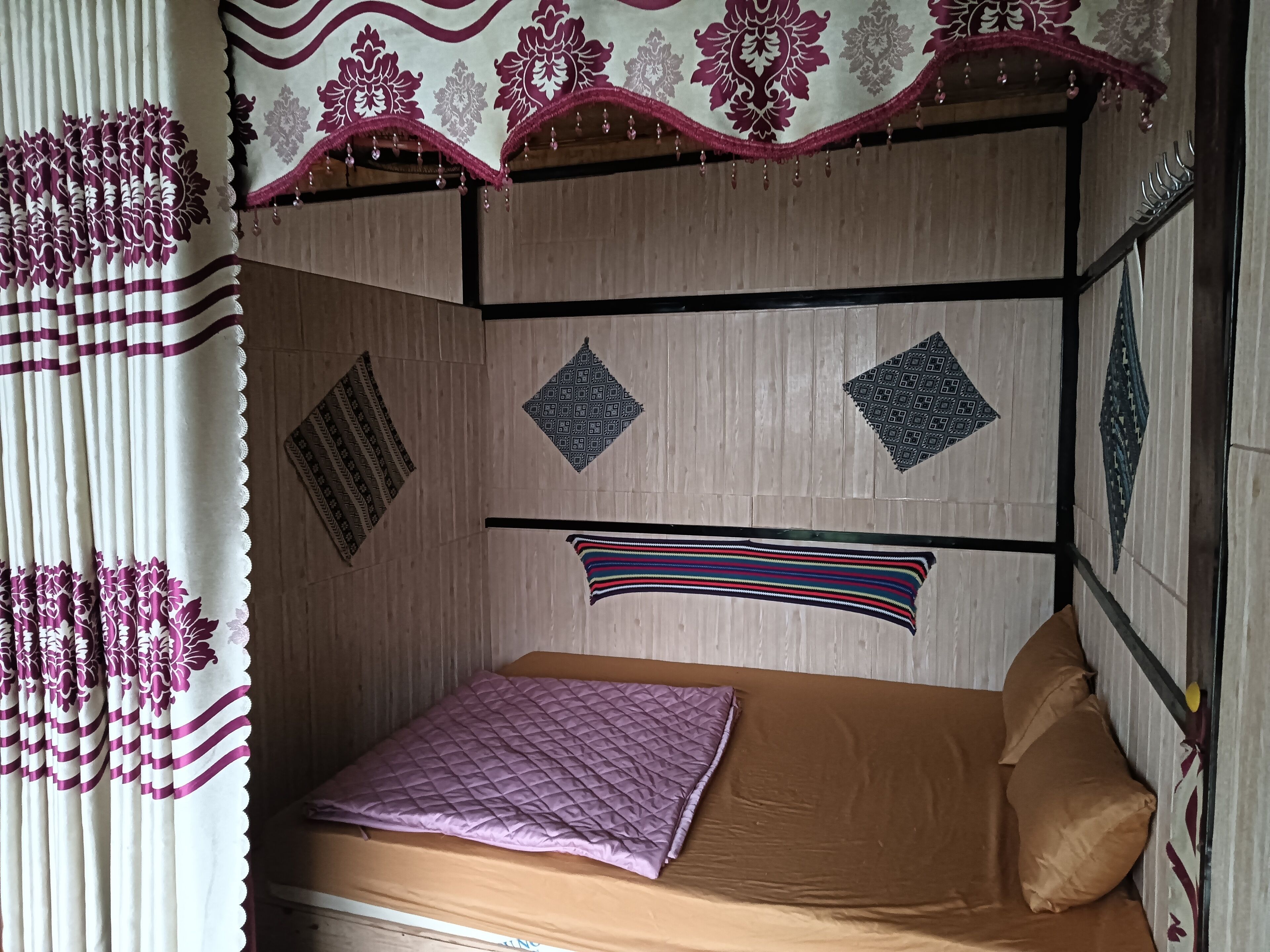 Una habitación con una cama, un adorno colgante y decoraciones murales estampadas.