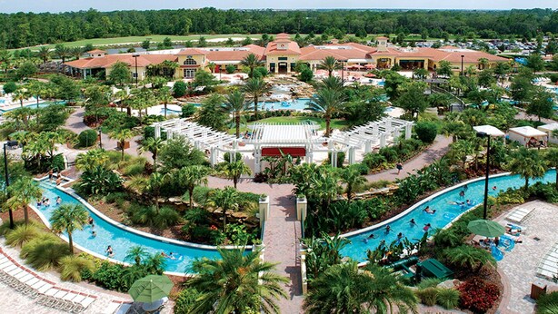 A resort with multiple swimming pools, palm trees, and a large building with a red roof.
