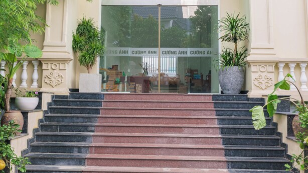 A grand entrance with a glass door, a green glass archway, and a staircase leading up to the entrance. - Cuong Anh House (Ho Chi Minh City)