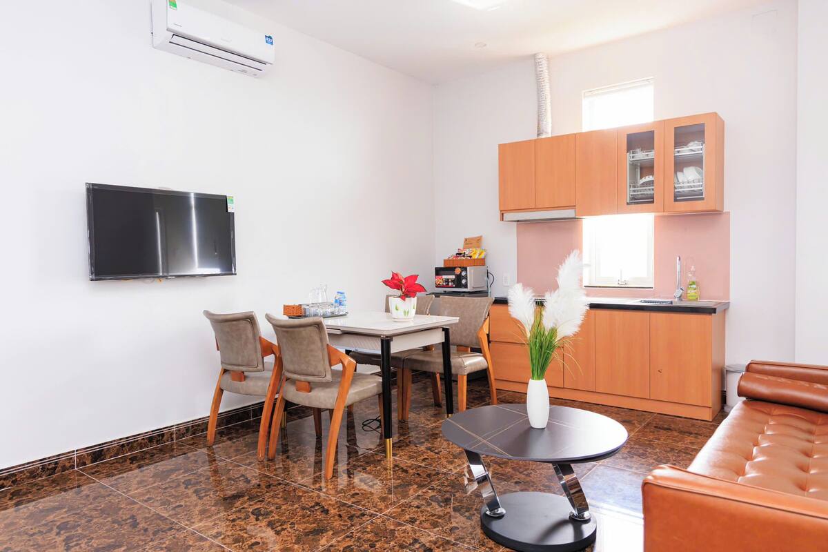 Un espace de vie compact comprenant un coin repas, une cuisine et un coin salon.