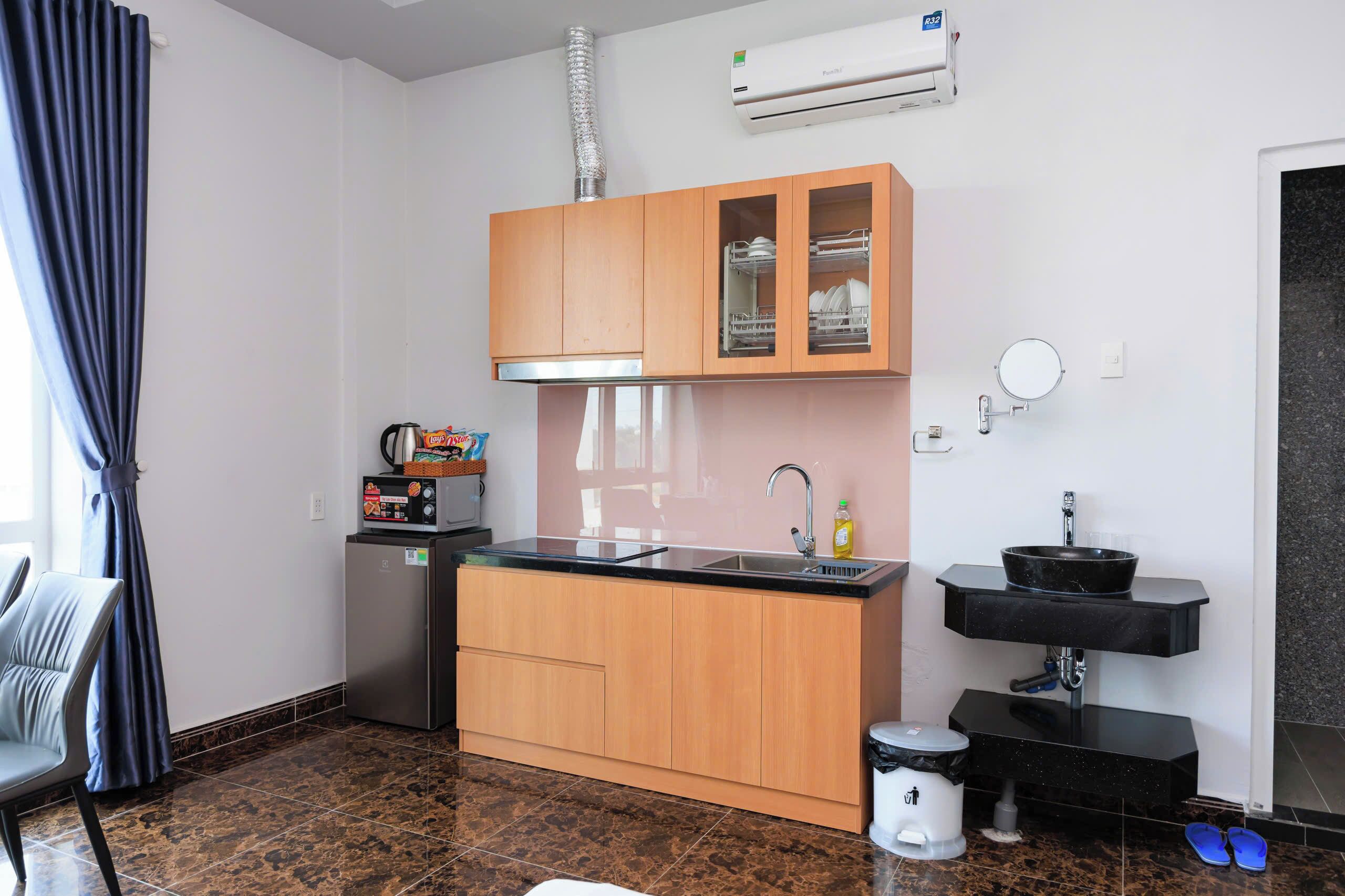 A compact kitchen with wooden cabinets, a built-in sink, and a compact refrigerator.