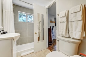 A bathroom with a bathtub, toilet, and sink. - The Barracks (Colorado Springs)