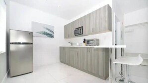 A modern kitchen with a stainless steel refrigerator, a microwave, and a built-in oven. - King Studio | Kitchen, Sofa Bed | Rooftop | Beach (Miami beach)