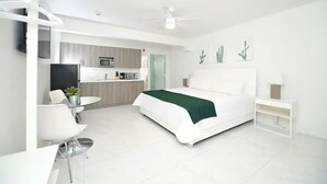 A modern hotel room with a bed, a desk, and a kitchenette. - King Studio | Kitchen, Sofa Bed | Rooftop | Beach (Miami beach)