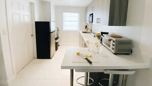 A modern kitchen with white countertops, a built-in oven, and a toaster.