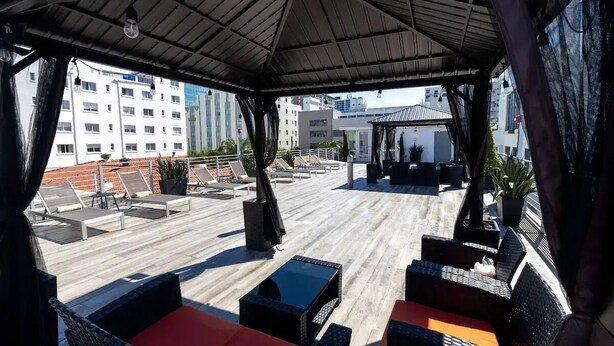 An outdoor seating area with wicker furniture and a covered section.