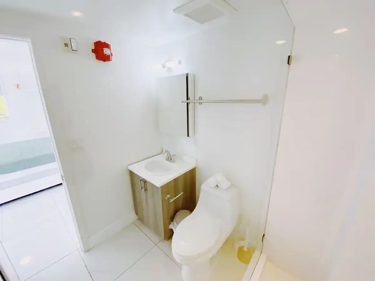 Une petite salle de bain moderne, équipée de toilettes, d’un lavabo et d’un miroir.
