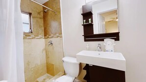 Un baño con ducha, inodoro y lavabo.