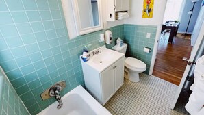 Un baño con bañera, lavamanos e inodoro.