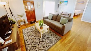Una sala de estar con un sofá, una mesa de centro y un televisor.