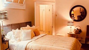 A bedroom with a bed, a ceiling fan, a mirror, and a nightstand. - Morocco Loft 2BR overlooking city walking mall  (Winchester)