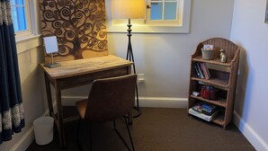 A corner room with a desk, chair, lamp, bookshelf, and a window. - Morocco Loft 2BR overlooking city walking mall  (Winchester)