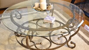 A glass-top table with a metal base, candles, and decorative stones. - Cute 3br Ranch, Home Away From Home, Sleeps 6 (Detroit)