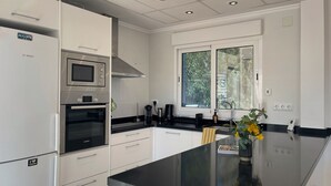 Eine moderne Küche mit Bosch-Geräten, einem großen Fenster und einer schwarzen Arbeitsplatte.