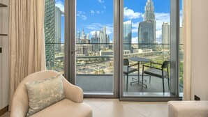 A modern living room with a large sliding glass door leading to a balcony with a city view. - NEW | 2BR Burj NYE Fireworks View | Dubai Mall (Dubai)