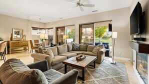 A spacious living room with a sectional sofa, a coffee table, and a fireplace. - PGA West Home | Private Pool & Fairway Views (La Quinta)