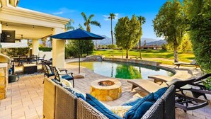 An outdoor patio with a pool, lounge chairs, and a fire pit. - PGA West Home | Private Pool & Fairway Views (La Quinta)