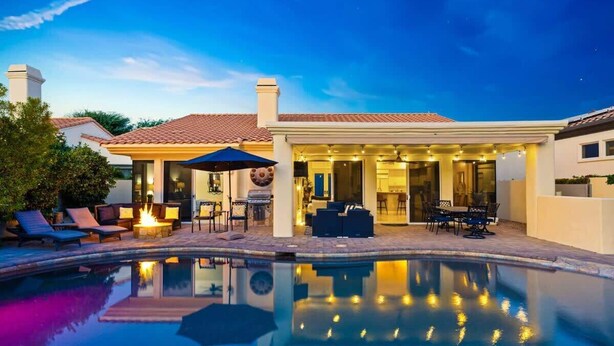 A modern house with a swimming pool, outdoor seating, and a covered patio area. - PGA West Home | Private Pool & Fairway Views (La Quinta)