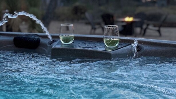 A pool with water jets and glasses of white wine. - The Pink Agave: Retro Glam Views+Cold Plunge+Hot Tub+Gym+Dog&Festival Friendly (Yucca Valley)