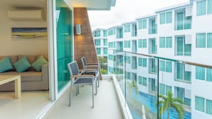 A modern hotel room with a balcony, a sofa, and a dining area. - Sea View Beach Dinning Beach Front c115 (Rawai)