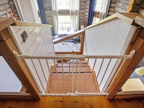 A wooden staircase with a metal railing leading to a loft area.