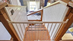 A wooden balcony with a white metal railing, stone walls, and a view of the outdoors. - Vacation home Naava by Interhome (Kittilä)