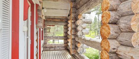 Una baita di legno con un patio e vista sulla foresta circostante.