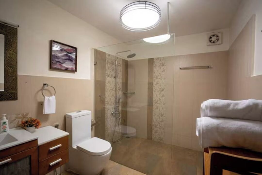 Un baño moderno con inodoro, lavabo y ducha.