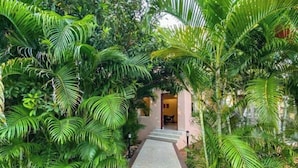 A pathway leading to a building surrounded by lush greenery. - Khushana Villa by Baywatch stayzz (Chennai)