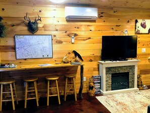 Enjoy a cozy evening by the fireplace, with a mounted TV and a bar area for socializing.
