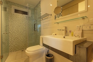 A modern bathroom with a glass shower enclosure, a white toilet, and a sink with a mirror above it. - Sea View Beach Dinning Beach Front c113 (Rawai)