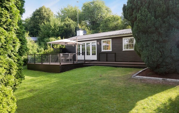 A cabin with a fenced deck, a covered patio, and a well-maintained lawn. - Two-bedroom pet friendly home in Holbæk (Holbæk)
