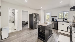 A modern kitchen with a central island, built-in appliances, and a view of the outdoors. - Aspen A-Frame Hot Tub Mountain Retreat Evergreen (Evergreen)