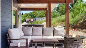An outdoor patio with a sofa, a table, and a fire pit.