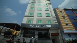 Un hotel a più piani con la scritta "HOTEL ROI INN" sulla facciata.