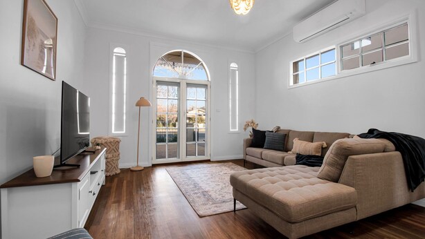 A living room with a sofa, TV, and a large window with a view.