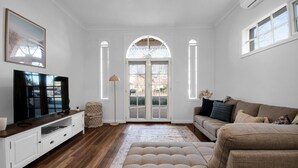 A living room with a television, sofa, and a large window.