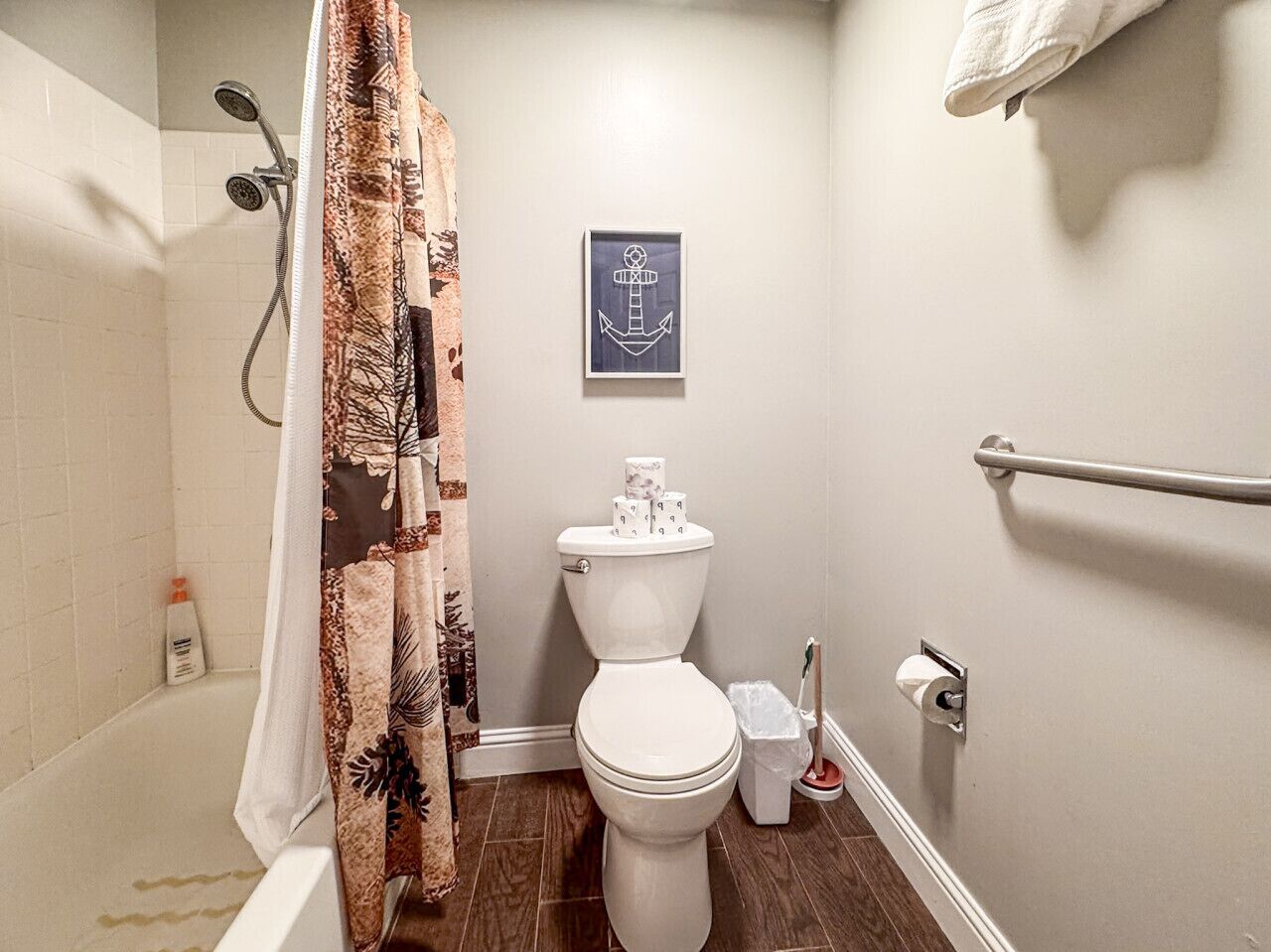 Une salle de bain avec une douche, des toilettes et un porte-serviettes.