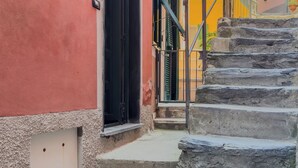 Un vicolo stretto con una scala di pietra che conduce a un edificio con una porta nera.