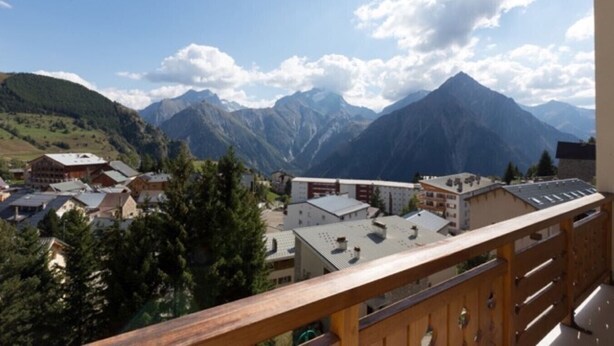 A mountain town with buildings and a prominent mountain in the background.
