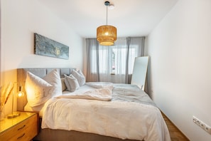 Une chambre à coucher avec un lit, une lampe de chevet et un luminaire suspendu.