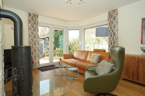 A living room with a sofa, armchair, and a fireplace.