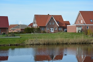 Zona residencial con casas, un estanque y cielo despejado.