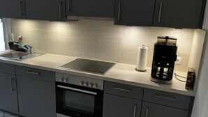 Une cuisine moderne équipée d’un four encastré, d’une machine à café et d’un distributeur d’essuie-tout.