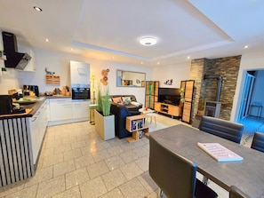 A modern living room with a TV, sofa, and dining area.