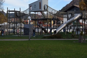 Leikkikenttä, jossa on kiipeilytelineitä ja liukumäki.