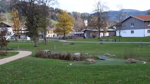 Ein Park mit einem gewundenen Pfad, Bänken und einem kleinen Teich.